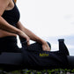Person holding a black CaliLuv yoga mat carrier against a scenic background. Made in California and made with hemp.